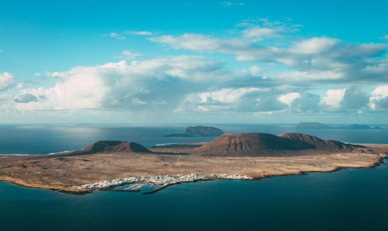 Aerial view of volcanic hills and a coastal village on Lanzarote in the Canary Islands.