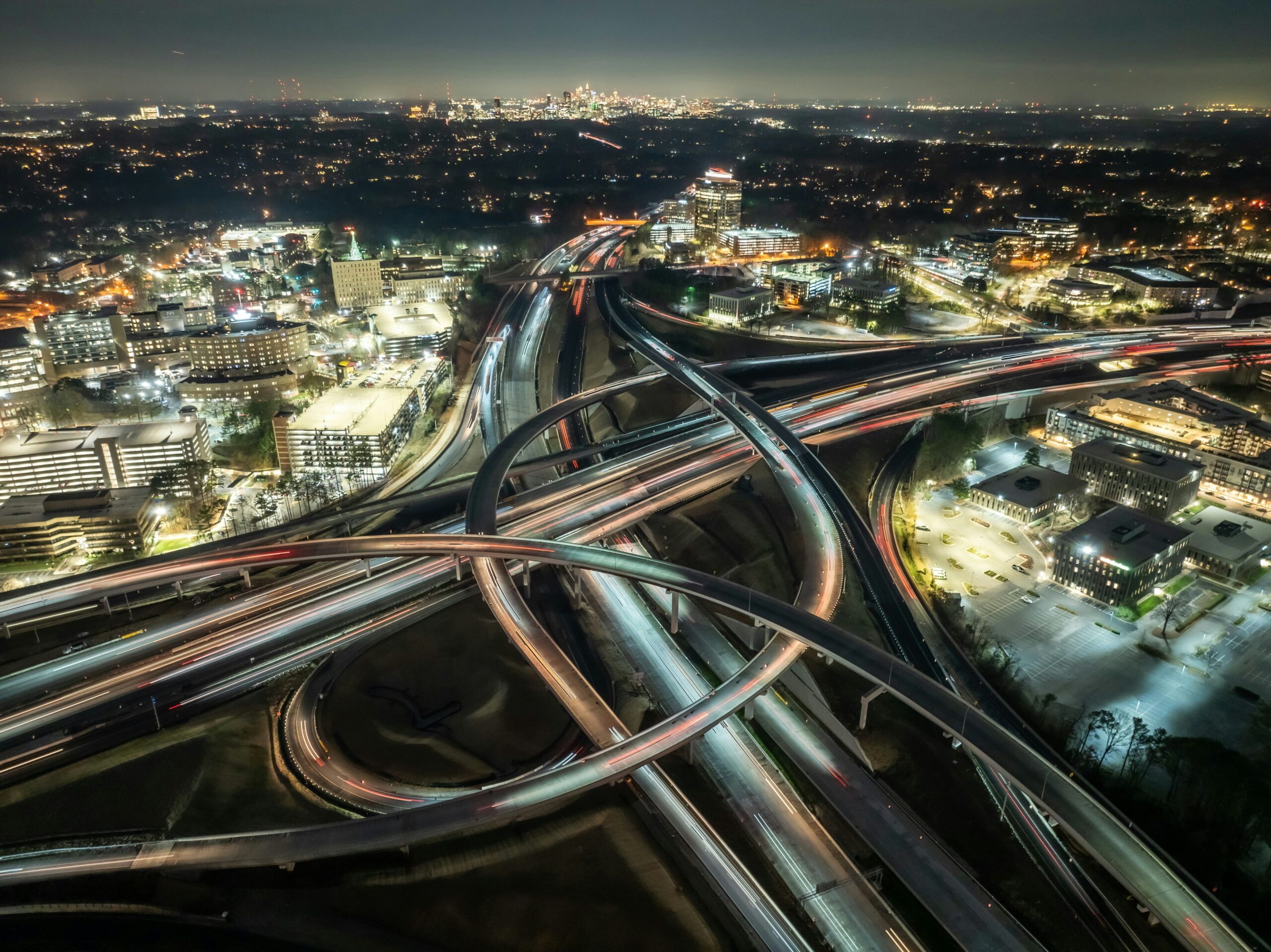 Aerial view of a large highway interchange with traffic at night in a city