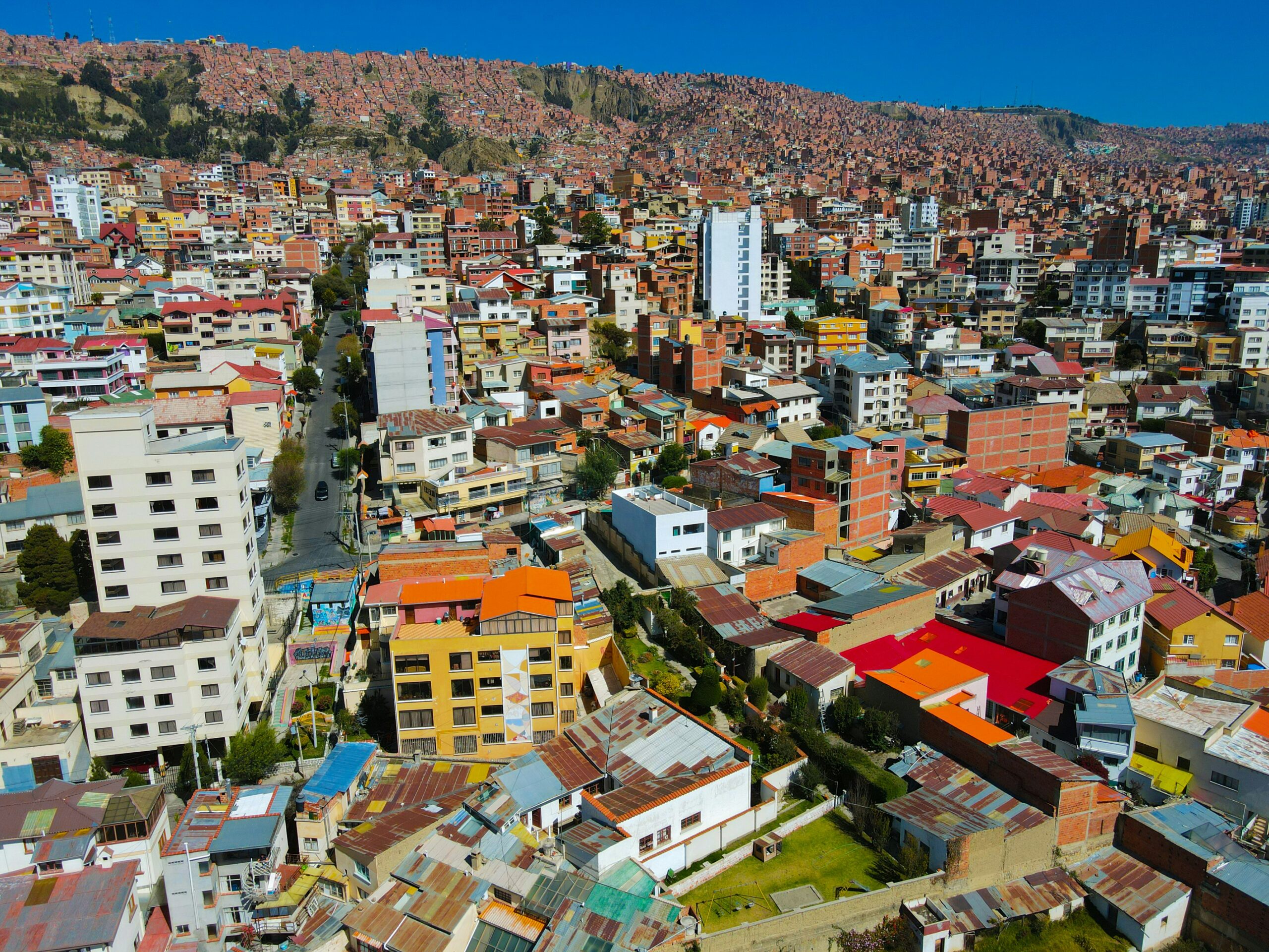Dense city neighbourhood with colourful buildings climbing steep hillsides.